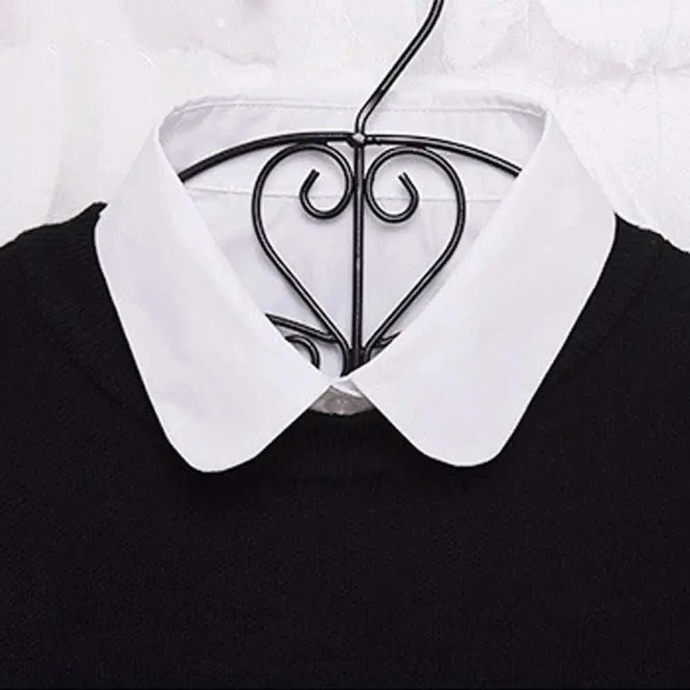 Detachable shirt collar in white on a black sweater, enhancing style and elegance.