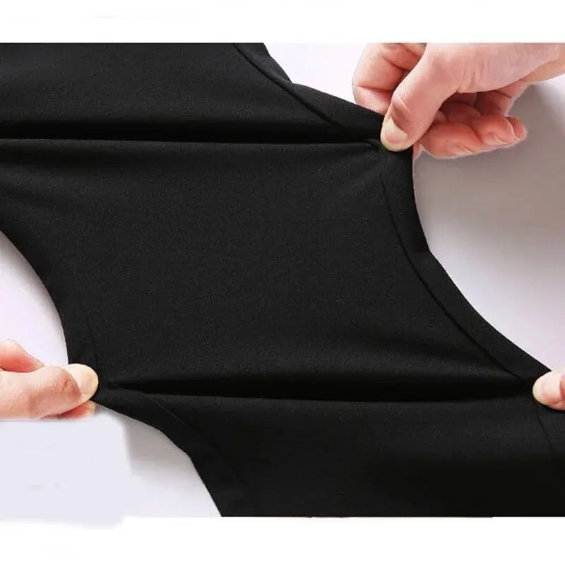 Stretchable fabric of black business casual suit pants being held to showcase flexibility.