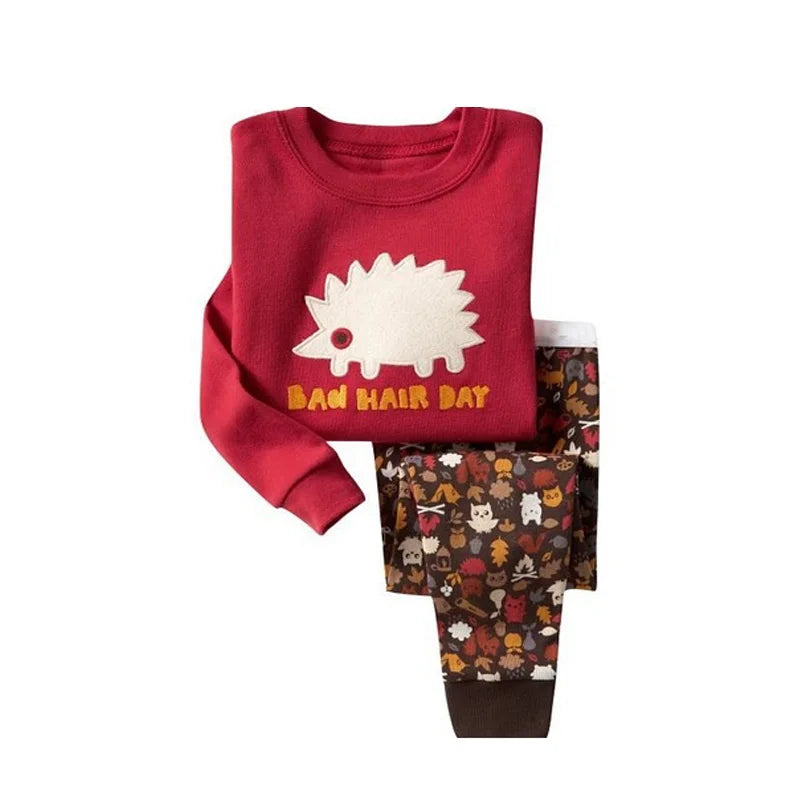 Kids Animal Pajama Set in red cotton knit, with a hedgehog graphic sweatshirt and brown animal-print pants with ribbed cuffs.