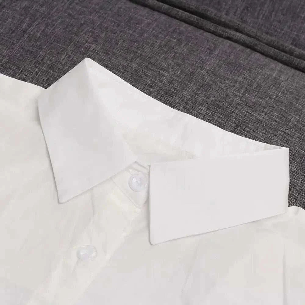Detachable shirt collar in white fabric, displayed on a dark background.