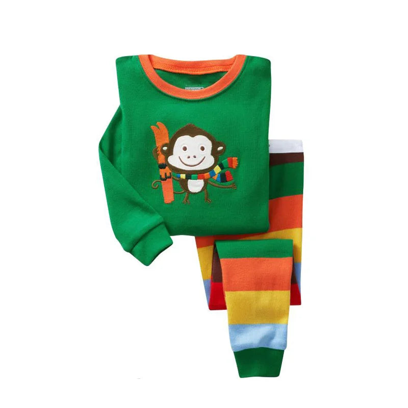 Kids Animal Pajama Set in green cotton knit, with an orange-trimmed monkey-print top and colorful striped pants.