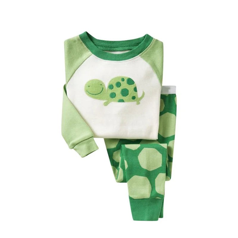 Kids Animal Pajama Set in soft green knit cotton, with a smiling turtle graphic and matching geometric-print pants.